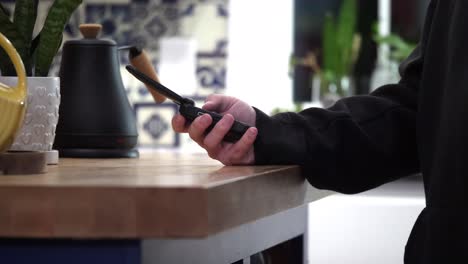 Person-opens-flip-phone-in-slow-motion-on-kitchen-counter