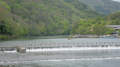 barco tradicional río abajo a través de las montañas y el bosque, arashiyama, kyoto, japón