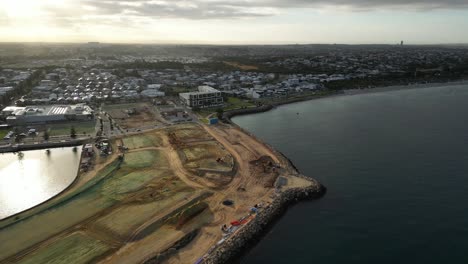 aerial flyover sandy construction site at port of coogee in perth city with suburb neighborhood at sunrise, wester australia - forward panorama shot