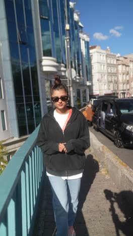 mujer caminando por un puente de la ciudad