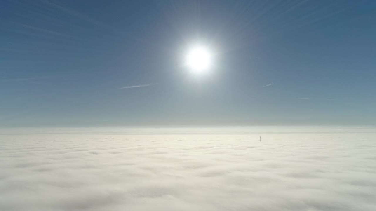 구름 아래 작은 영광과 도시 풍경을 가지고 아침 햇빛에 안개 낀 구름 위로 비행