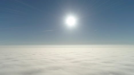 flight over misty clouds in morning sunlight with little glory and city scape under clouds