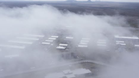niebla que cubre la ciudad de njáránvök en islandia con varios edificios, antena aérea