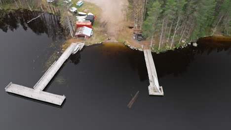 Wooden-Pier-And-Campers-Near-Peaceful-Lake-And-Autumn-Forest-Trees-In-Sweden