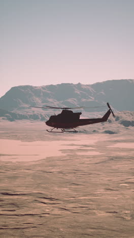 helicopter flying over a desert landscape