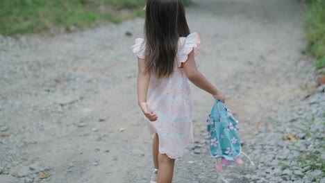 a pregnant woman and her young daughter, both dressed in white, walk hand-in-hand through a grassy park. the scene captures a serene moment of family bonding in nature, surrounded by trees.