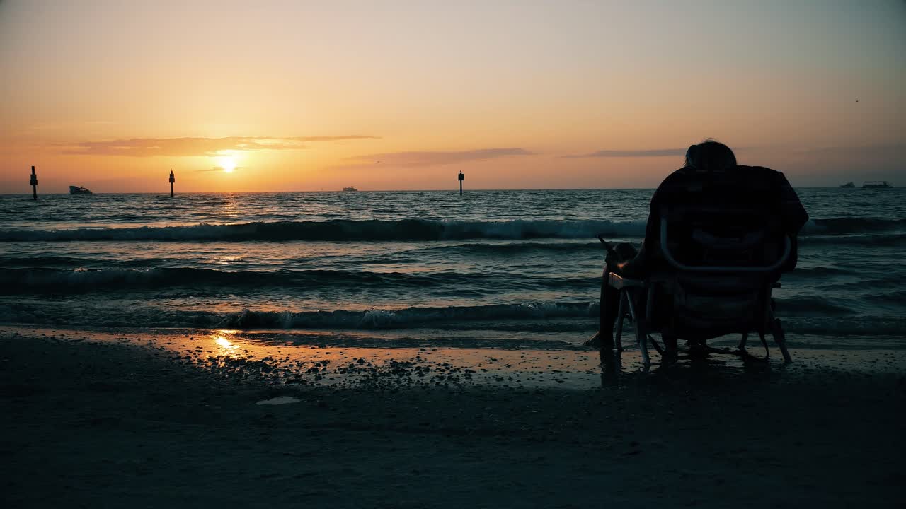 Silhouette of Person Sitting on Beach Watching Ocean Sunset