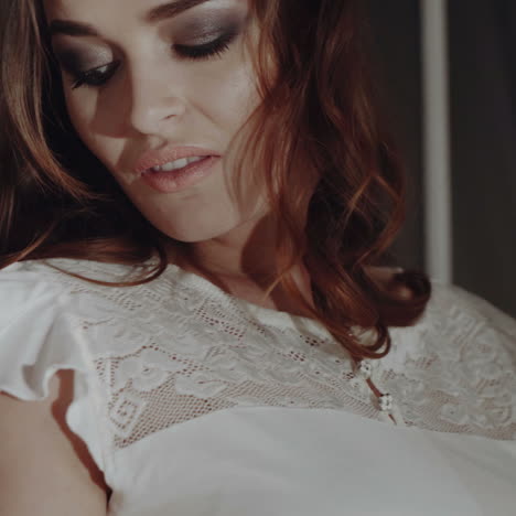 seductive girl in lacy nightwear sits on the window sill of a large window. the ideal body of a young woman. underwear.