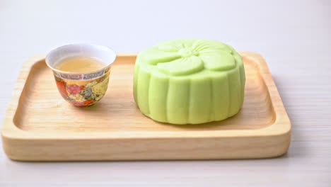 Pastel-De-Luna-Chino-Sabor-A-Té-Verde-Con-Té-En-Placa-De-Madera