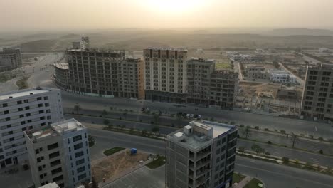 Aerial-drone-rotating-shot-over-multi-storied-buildings-close-to-Sindh-Square-Roundabout-in-Bahria-Town,-Karachi,-Pakistan