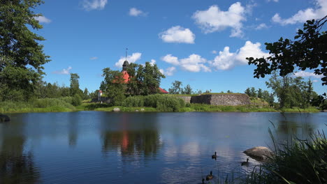 Ducks-swimming-on-the-calm-water-of-a-lake-adjacent-to-the-Museum-fortress-korela,-Russia