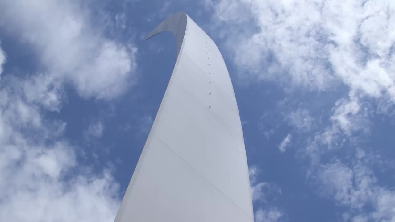 Nærbillede i frøperspektiv af spiret på U.S. Air Force Memorial i Arlington, Virginia nær Washington, D.C., et monument i rustfrit stål, der rejser sig mod en skyet himmel om dagen.