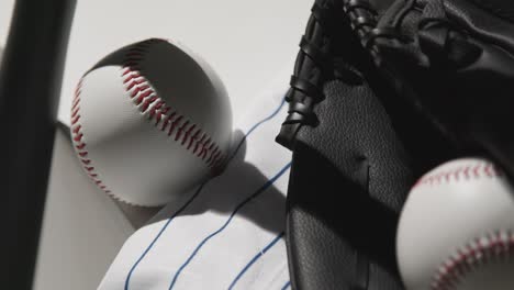 close up studio baseball still life with bat ball catchers mitt and team jersey