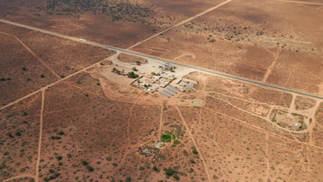 vista aérea de una gasolinera autosuficiente, alimentada por celdas de energía solar, en el interior de australia - retroceso, disparo de drones
