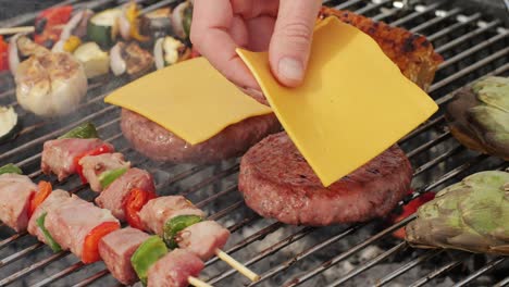 grilled burgers, corn, and vegetables on the barbecue