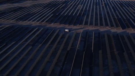 Vista-Aérea-De-Una-Enorme-Planta-De-Energía-Solar,-Conjuntos-De-Paneles-Solares-En-El-Crepúsculo,-Revelando-Un-Disparo-De-Un-Dron