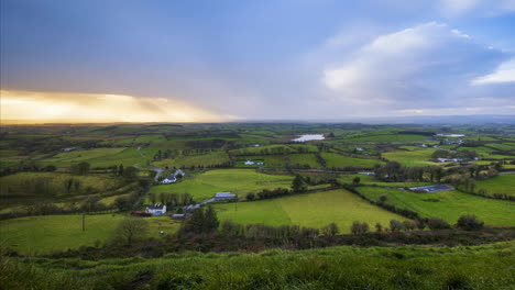 Time-lapse-of-rural-farming-landscape-of-grass-fields-and-hills-during-dramatic-cloudy-sunset-viewed-from-Keash-caves-in-county-Sligo-in-Ireland
