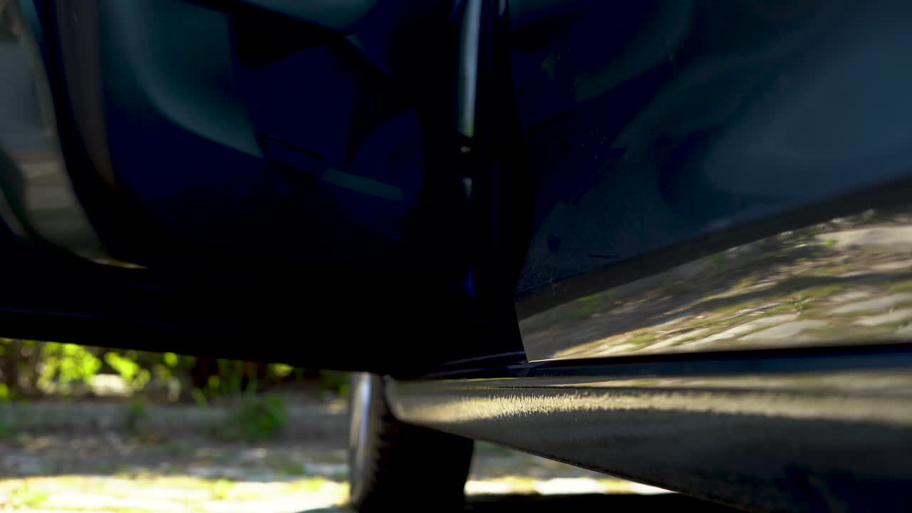 человек открывает дверь машины, выходит и закрывает ее.