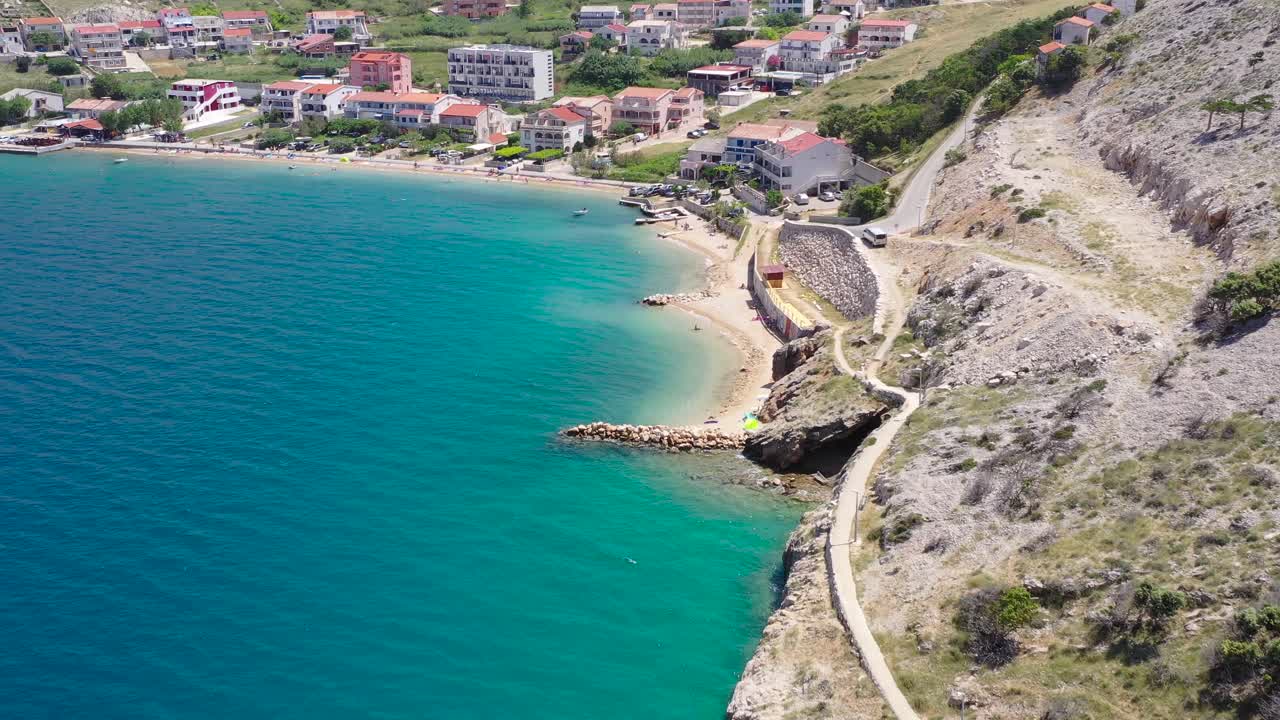 Resort beach area from the town of Metajna on the island of Otok Pag in Croatia, Aerial flyover approach view