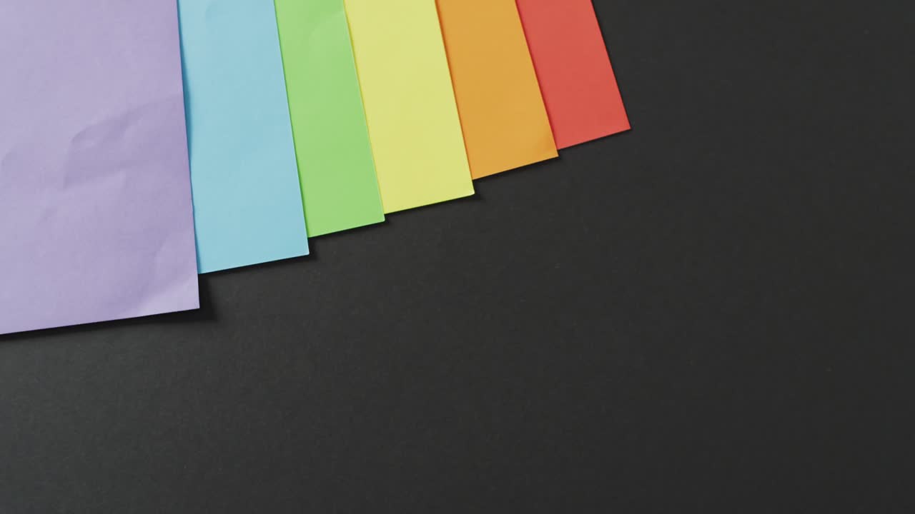 복사 공간과 함께 검은 배경에 무지개 시트의 비디오