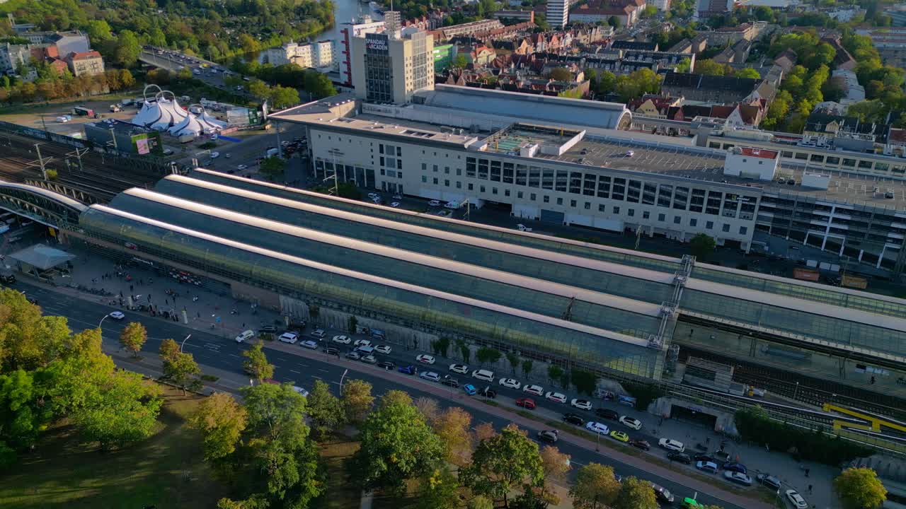 Berlin Spandau train station and Mall shopping center with surrounding urban landscape. Unbelievable aerial view flight drone shot from above