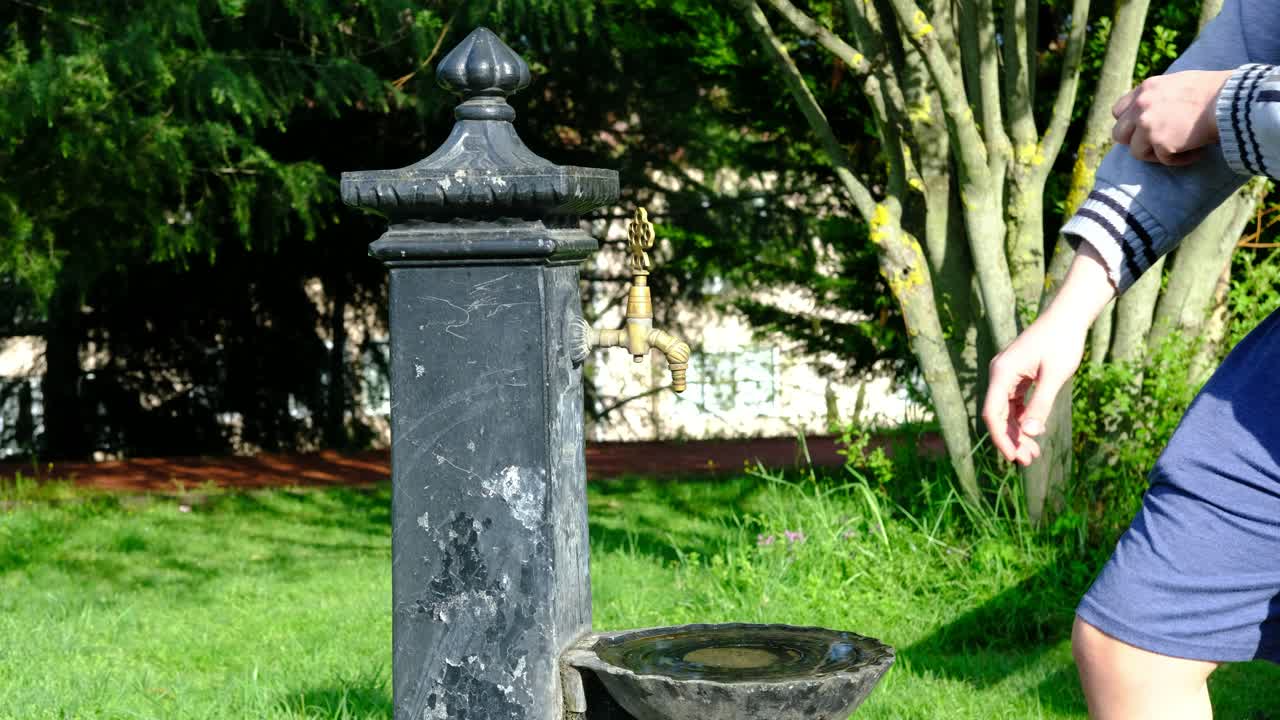 un adolescente que se lava las manos