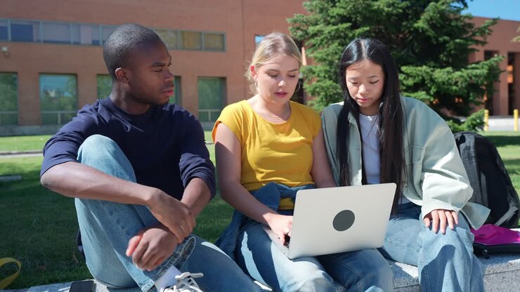 Students working on laptop together on campus