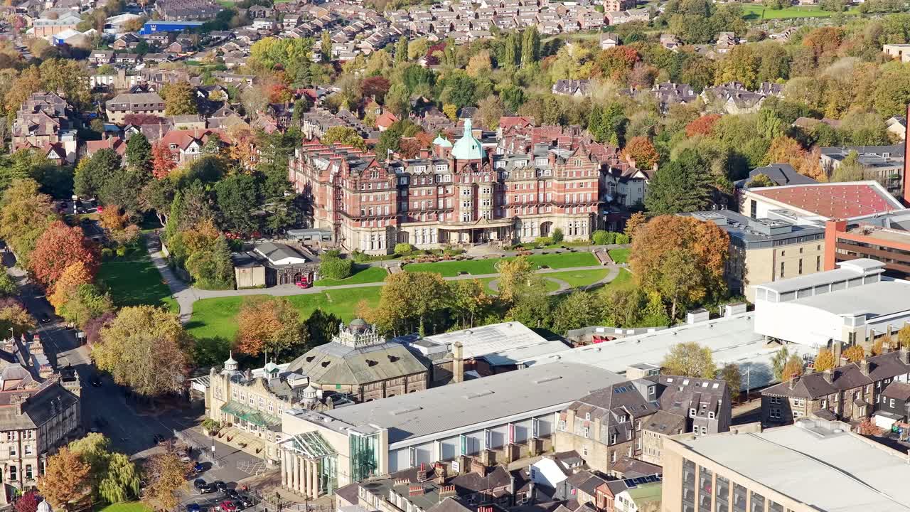 Majestic Hotel dominates central Harrogate in this drone shot, displaying its grand Victorian architecture, domed roof, and manicured lawns, with residential areas and autumn foliage, drone shot