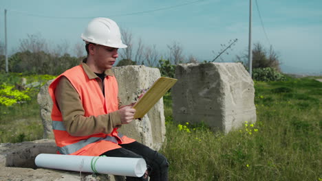 architect in the nature sitting while taking notes about the project