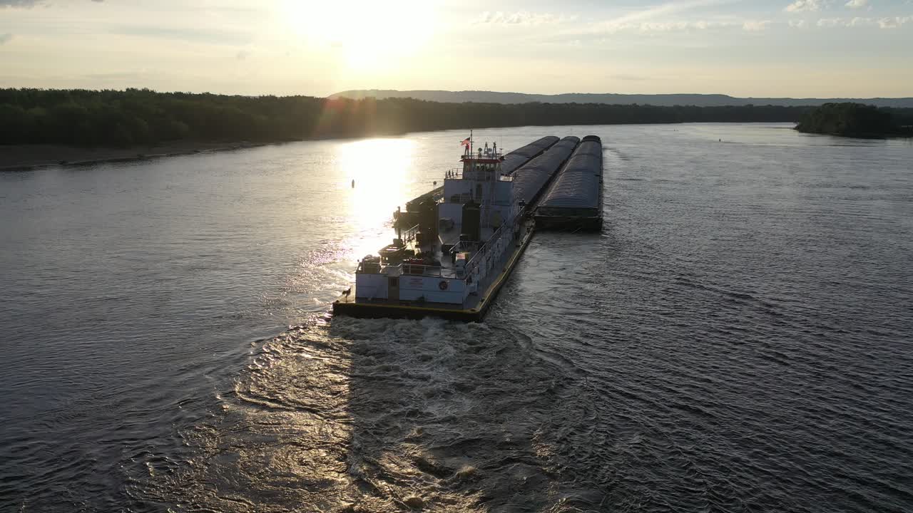 해가 지는 강 에서 견인 보트 와 바지