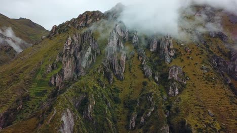 Aerial,-tracking,-drone-shot-of-low-clouds-on-rocky-Andes-mountains,-on-a-cloudy-day,-near-Cusco,-in-Peru,-South-America