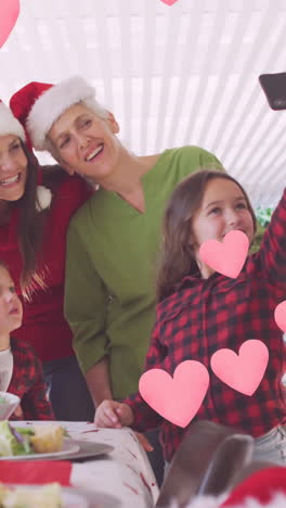 animación de corazones sobre una feliz familia caucásica tomando una selfie