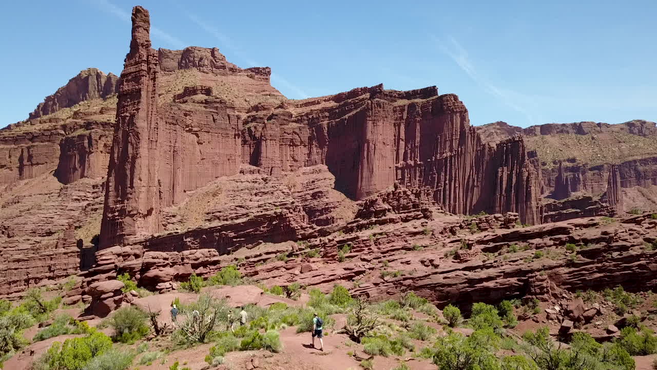 Escursionisti sul sentiero Fisher Towers verso il pinnacolo di roccia rossa The Titan