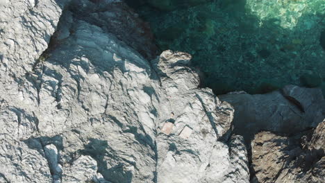 Langsam-Fliegen-über-Felsen-Am-Mourtias-Beach,-Griechenland