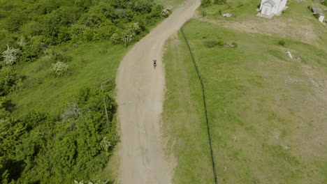 Motorcycle-emerging-from-the-forest-and-driving-on-an-off-road-trail-in-Kojori