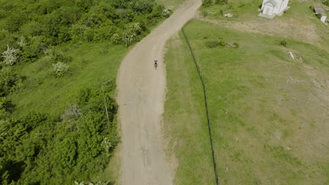 motocicleta que emerge del bosque y conduce por un sendero todoterreno en kojori