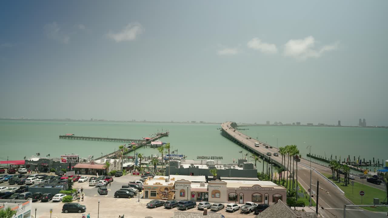 vista desde port isabel texas con vistas a la carretera sobre el agua a la isla del padre sur con turistas conduciendo autos a las vacaciones de verano