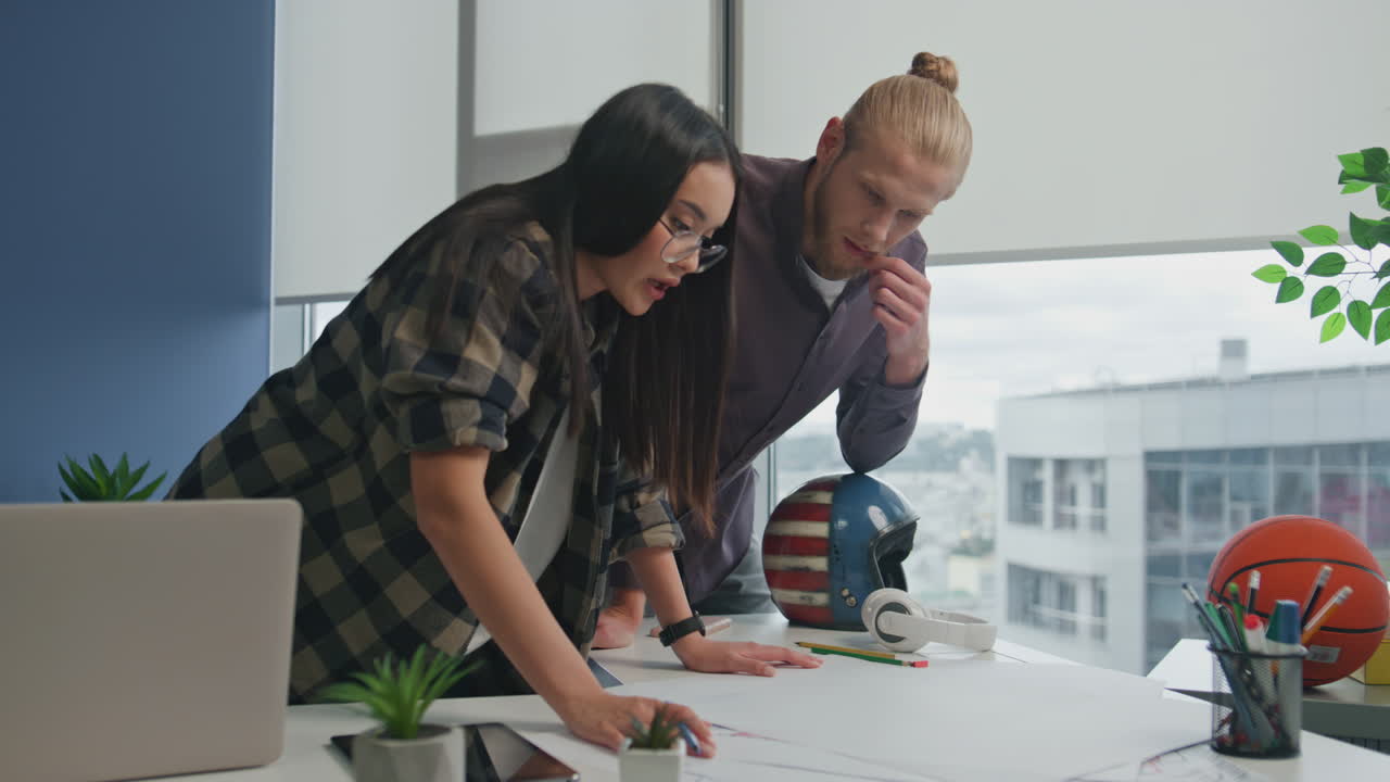 diversos diseñadores haciendo una lluvia de ideas en la oficina. mujer dibujando un plan de construcción.