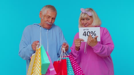 los abuelos mayores muestran bolsas de compras y hasta un 40 por ciento de descuento en el texto del cartel, el viernes negro.