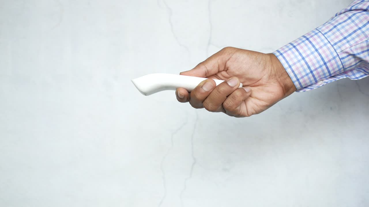 persona que tiene un termómetro sin contacto