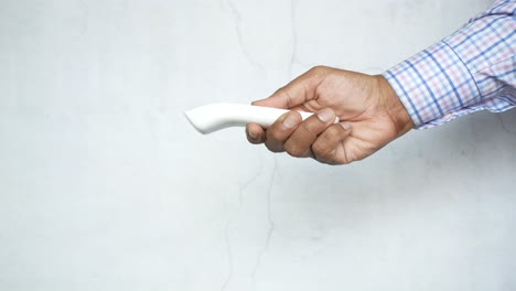 person holding a non-contact thermometer