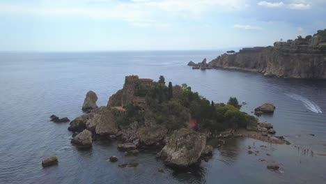 this is a drone shot of isola bella in taormina, sicily island