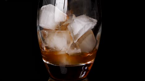 close up shot of making ice coffee drink with ice cubes in glass