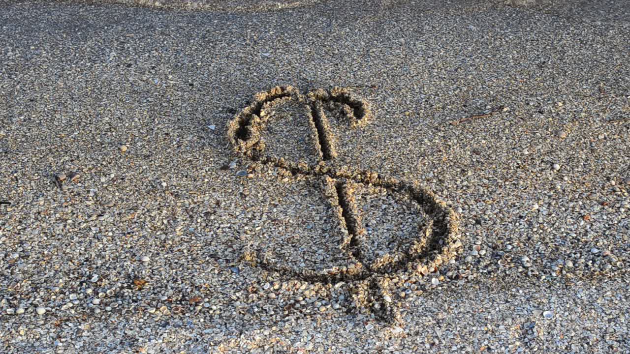 Simbolo del dollaro sulla sabbia. Sabbia e valuta.