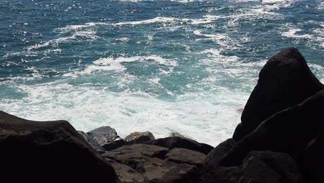 HD-Slow-motion-Hawaii-Kauai-static-looking-down-on-ocean-waves-crashing-with-lava-rock-in-foreground,-three