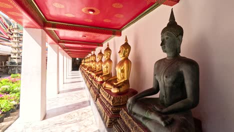 estatuas de buda alineadas bajo un techo rojo