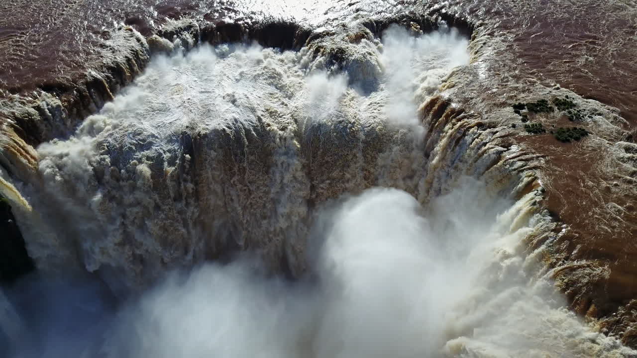 Zenithal ascent from the magnificent Devil's Throat, showcasing the impressive water flow of Iguazu Falls, capturing the sheer force and natural grandeur of this iconic cascade