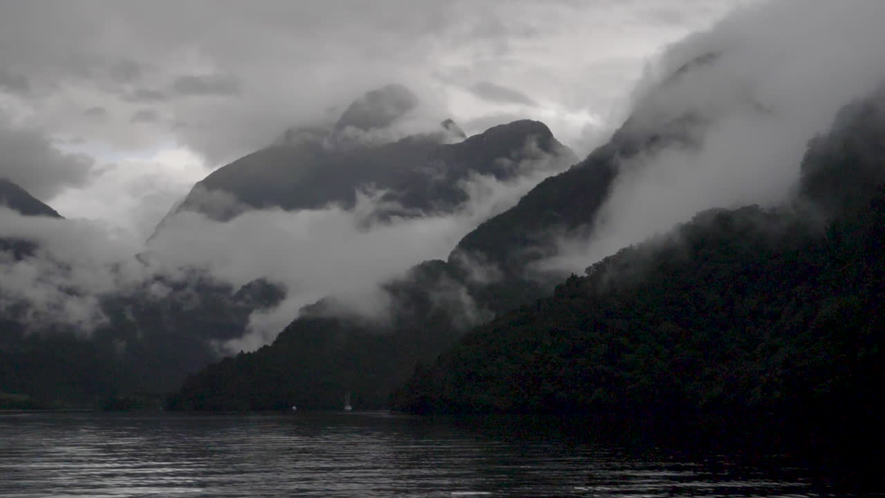 앞면 에 물 이 있는 의심 스러운 소리 로 안개 와 구름 이 가득 찬 산 들 의 느린 움직임 의 정적 영상 - 파테아, 뉴질랜드