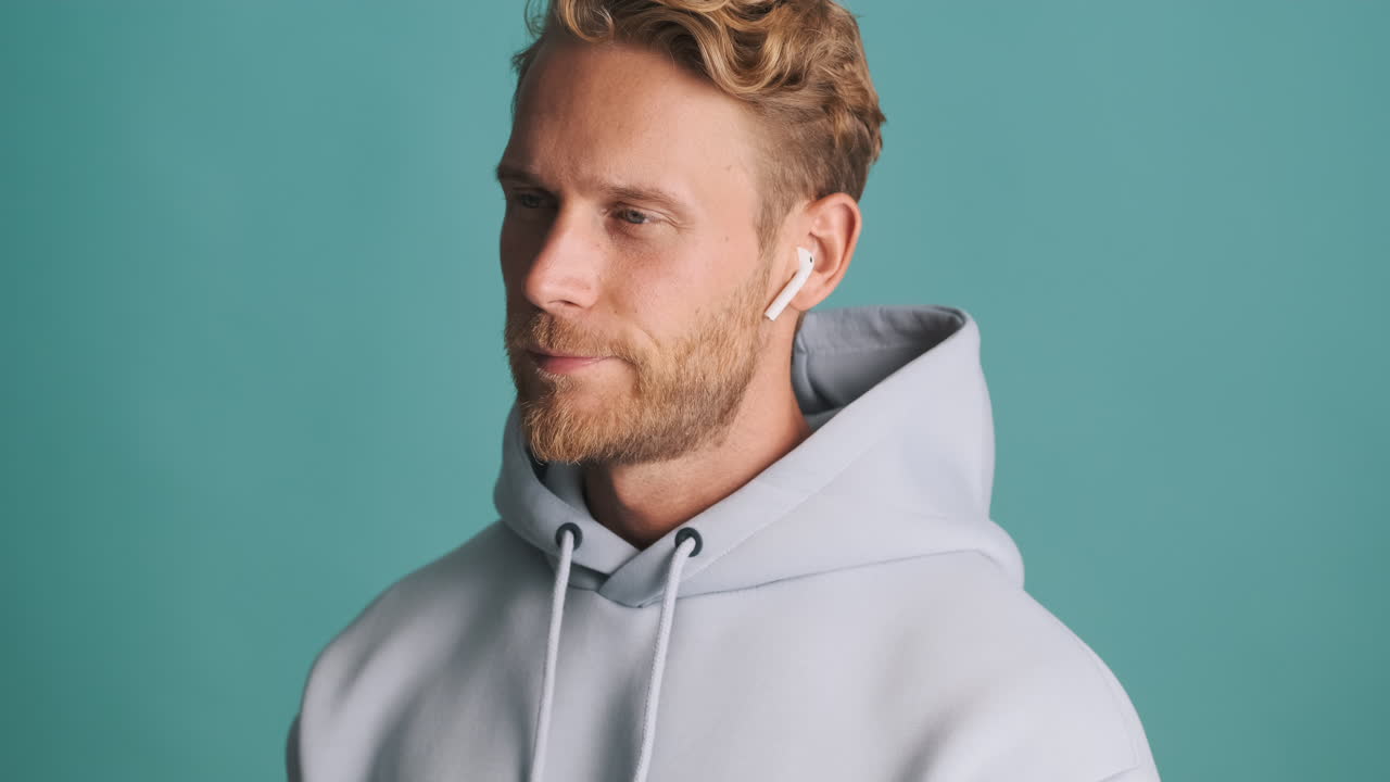 hombre barbudo hablando y usando auriculares