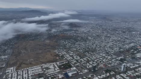drone aéreo disparado por encima de las nubes de un pequeño pueblo en un día nublado